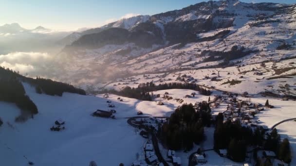 Schöner Sonnenuntergang in einem schneebedeckten Winterskigebiet in den Alpen, Antenne Vorwärts Dolly — Stockvideo