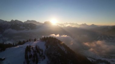 Mistik güneş ışınları bulutların arasında parlıyor ve yüksek dağ zirvesinde, havada dönüyor.
