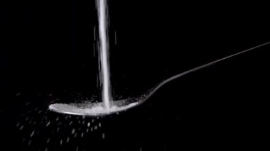 Sağlıksız şeker düşüyor ve bir yemek kaşığını dolduruyor, yavaş çekim, izole edilmiş