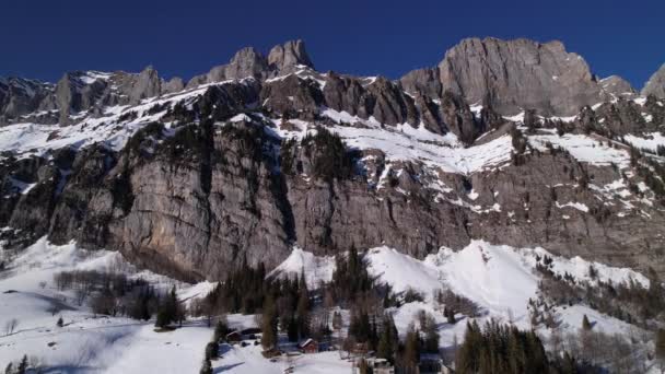 Laterales aéreos que muestran majestuosas cumbres montañosas desde los alpes suizos en invierno — Vídeos de Stock