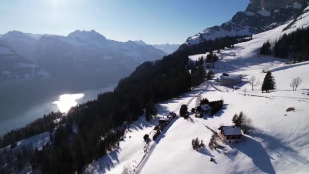 Kar altında küçük bir dağ köyü kurmak harika bir İsviçre gölü manzarası. — Stok video