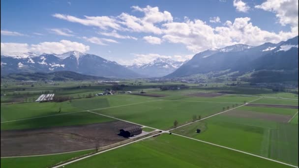 スイスの谷に牛を持つ農家の上に後方にドリードローン,ハイパーラプス — ストック動画