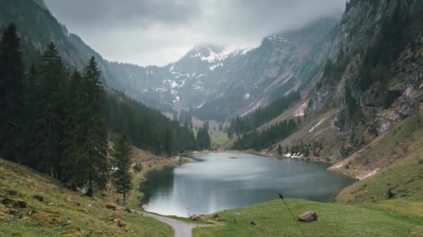 Zoom out Time-Lapse to reveal a majestic Swiss alpine lake panorama with rain Royaltyfri Stockvideo