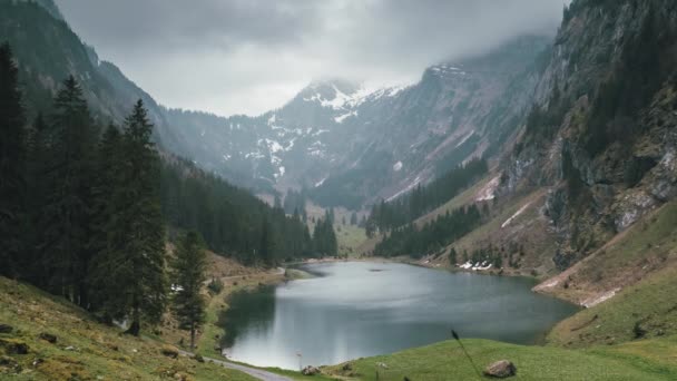 Fairytale lake surrounded by huge mountains in the Swiss alps on a cloudy day Videoklipp