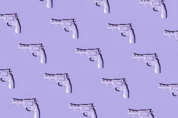 紫色背景的紫罗兰枪的彩色彩绘图案 最小武器概念 平躺手枪构图 — 图库照片
