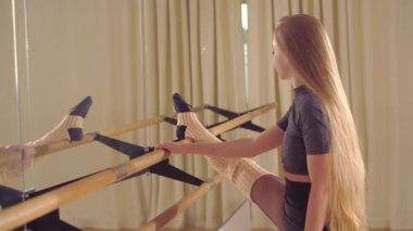 Balerin salonda bir bale barıyla antrenman yapıyor.