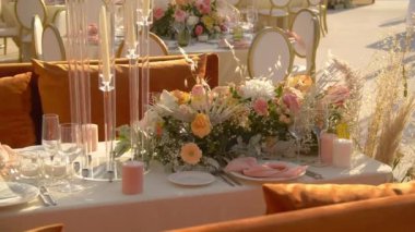 Masa örtülü masa, beyaz tabaklar, taze çiçekler, bir restoranda düğün yemeği.