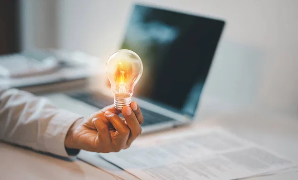 Hand Holding Light Bulb Laptop Wooden Desk Creative New Idea Imagen De Stock