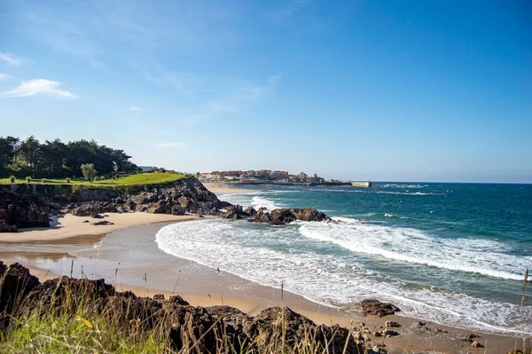 Deniz dalgaları ve mavi gökyüzü olan güzel sahil
