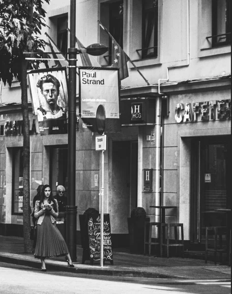 Şehirde genç ve güzel bir kadının siyah beyaz fotoğrafı.