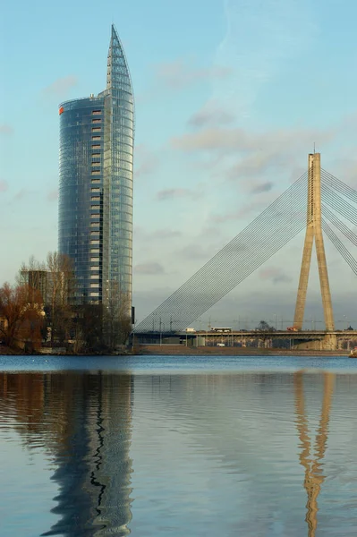 Letonya 'nın Riga kentinde, Daugava Nehri' nin sularına yansıyan, Kablo Kalan Köprü yakınlarındaki çok katlı cam bir banka binası.