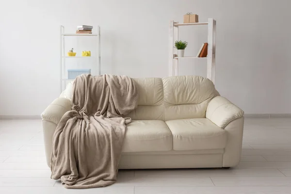 在简朴的客厅里，米色的沙发靠着白色的空墙。最低纲领概念. — 图库照片