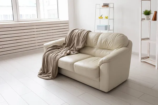 Divano beige contro parete bianca vuota in semplice soggiorno interno. Concetto minimalismo. — Foto Stock