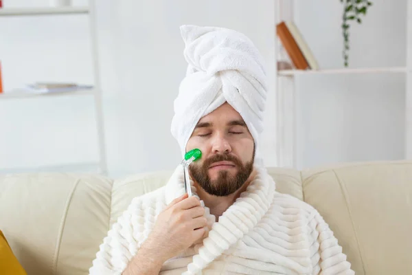 Hombre barbudo con herramienta de masaje facial. Cuidado de la piel masculina y concepto de spa. —  Fotos de Stock