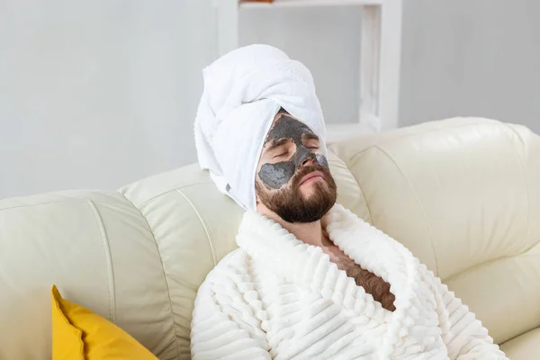 O homem barbudo tem pele fresca limpa, usa máscara de barro de beleza no rosto e gosta de tratamentos de beleza. Spa em casa, corpo e cuidados com a pele — Fotografia de Stock