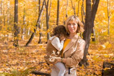 Anne sonbahar doğasında ağlayan küçük kızını teselli ediyor. Duygular ve aile kavramı.