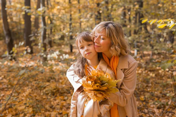 Mladá matka se svou dcerou v podzimním parku. Podzimní sezóna, rodičovství a dětský koncept. — Stock fotografie