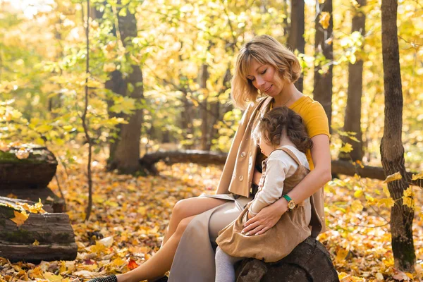 Madre e hija disfrutando de un bonito día de otoño en un parque. Concepto de temporada, familia e hijos. — Foto de Stock