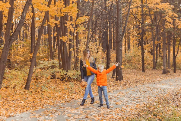 Мать и сын гуляют по осеннему парку и наслаждаются красивой осенней природой. Концепция сезона, родителей-одиночек и детей. — стоковое фото