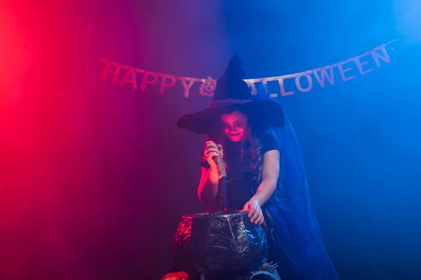 Petite sorcière enfant cuisson potion dans le chaudron sur Halloween. — Photo
