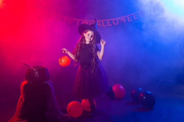 Enfant drôle fille en costume de sorcière pour Halloween avec citrouille Jack. — Photo