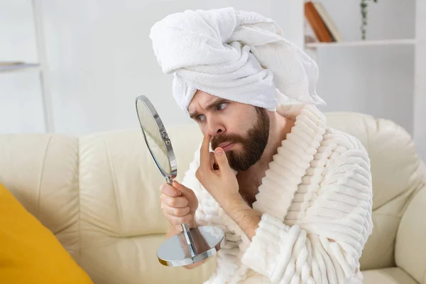 Homem barbudo a verificar a pele da cara. Spa, corpo e cuidados com a pele para o conceito masculino. — Fotografia de Stock