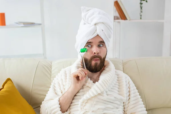 Homem engraçado com ferramenta de massagem facial. Cuidados com a pele masculina e conceito spa. — Fotografia de Stock