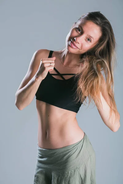 Fitness és diéta koncepció. Portré fiatal nő tökéletes sportos test és szép lapos has szexi sportruházat top szürke háttér. — Stock Fotó