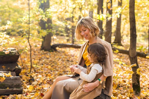 Мать и маленькая дочь наслаждаются прекрасным осенним днем в парке. Концепция сезона, семьи и детей. — стоковое фото