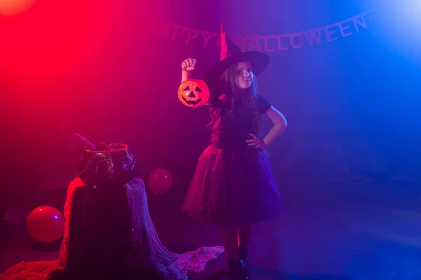Petite fille tient citrouille Jack sur Halloween vacances. La gamine porte un costume de sorcière. Fantaisie, conte de fées et concept de mascarade. — Photo