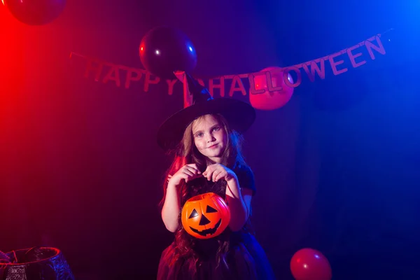 Funny niña en traje de bruja para Halloween con Jack de calabaza. —  Fotos de Stock