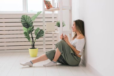 Evde oturup fincandan çay içen hayalperest kız..