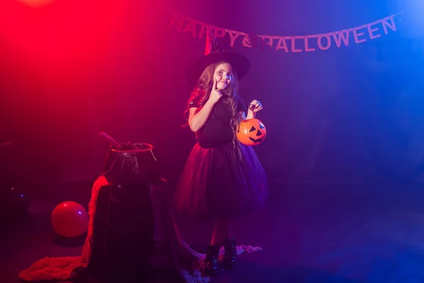 Petite fille tient citrouille Jack sur Halloween vacances. La gamine porte un costume de sorcière. Fantaisie, conte de fées et concept de mascarade. — Photo