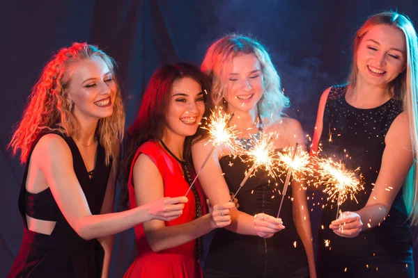 Festa de aniversário, conceito de ano novo e feriados - Grupo de amigas celebrando segurando sparklers — Fotografia de Stock