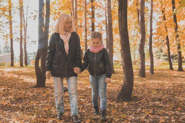 Abuela con nieta en el parque de otoño. Generación y concepto familiar. —  Fotos de Stock