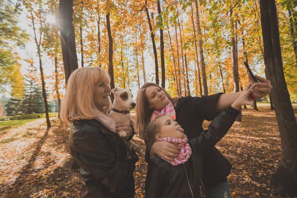 Tre generationer av kvinnor och hund känner kul titta på kameran poserar för självporträtt bild tillsammans, rolig glada barn, mamma och mormor ha kul njuta helg selfie på gadget i höst — Stockfoto