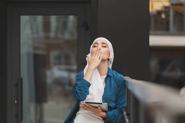 Красивые азиатские бизнесмены носят хиджаб, используя свой планшет на открытом воздухе. — стоковое фото