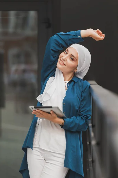 Mobil tabletli, başörtülü, genç Asyalı Müslüman kadın. — Stok fotoğraf