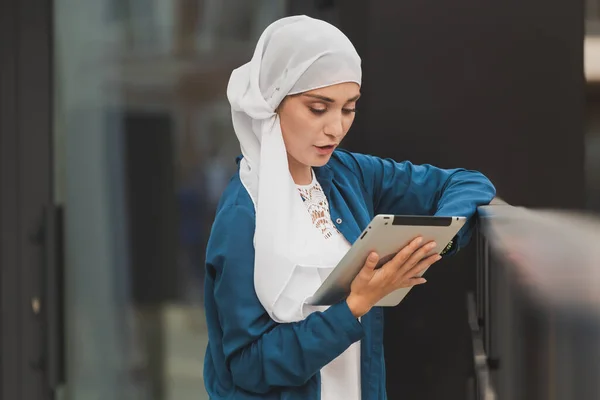 Sorrindo menina muçulmana usando tablet digital, navegação na Internet ou redes sociais ao ar livre — Fotografia de Stock