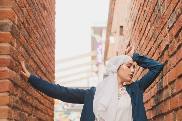 Türbanlı modern Müslüman kız modası. Başörtüsü takan güzel Müslüman kadın modeli ve şehir arka planında poz veren günlük kıyafetler. — Stok fotoğraf