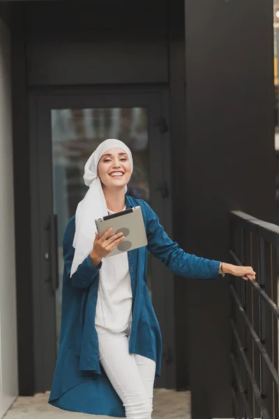 Güzel Müslüman kız dışarıdaki arkadaşıyla iletişim kurmak için dijital tablet kullanıyor. — Stok fotoğraf