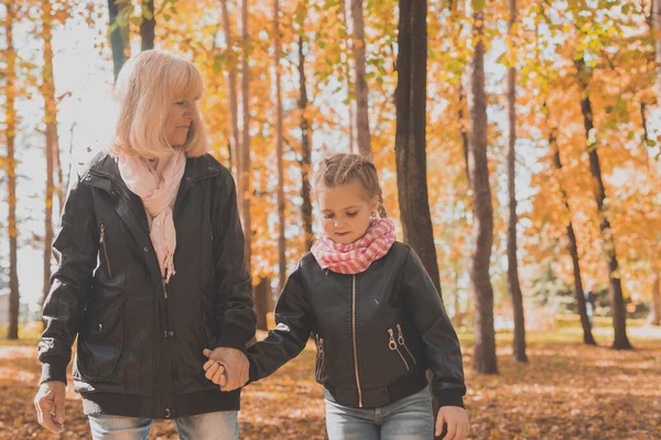 Abuela con nieta en el parque de otoño. Generación y concepto familiar. —  Fotos de Stock