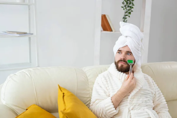 Hombre barbudo con herramienta de masaje facial. Cuidado de la piel masculina y concepto de spa. —  Fotos de Stock