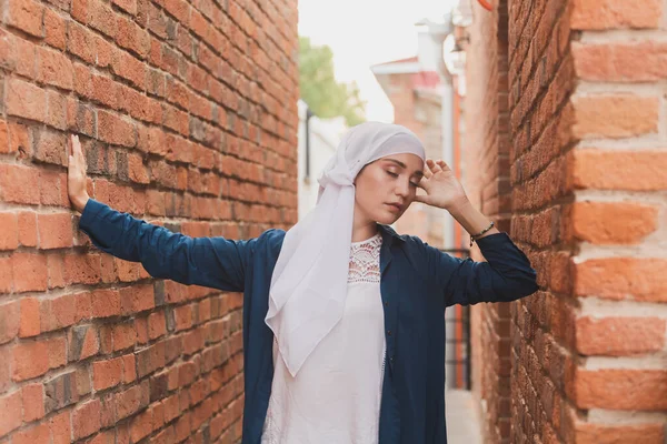 Türbanlı modern Müslüman kız modası. Başörtüsü takan güzel Müslüman kadın modeli ve şehir arka planında poz veren günlük kıyafetler. — Stok fotoğraf
