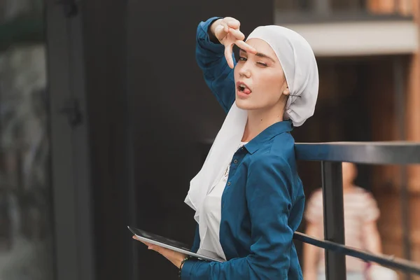 Junge asiatische Muslimin mit Kopftuch lächelt mit Handy-Tablet und Kopierraum — Stockfoto