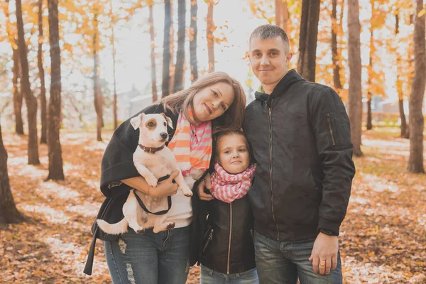 Rodina tráví čas v podzimním parku se psem. Otec, matka a dcera a Jack Russell teriér pes baví na podzim — Stock fotografie