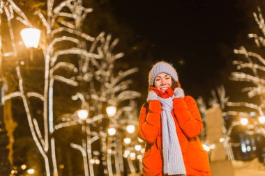 Genç, güzel, komik kız kışın dışarıda eğleniyor. Noel, şehir ve kış tatili konsepti.