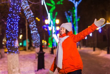 Genç, güzel, komik kız kışın dışarıda eğleniyor. Noel, şehir ve kış tatili konsepti.