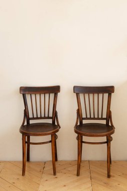 İki tahta sandalye ve beyaz duvar arkaplanı