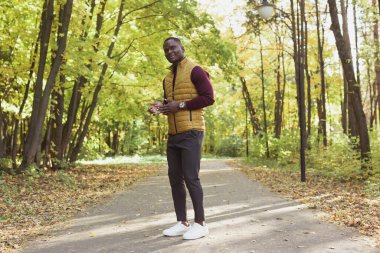 Parkta yürüyen Afrikalı Amerikalı erkek öğrenci